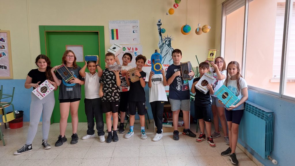 Alumnado muestra instrumentos creados durante un proyecto escolar.
